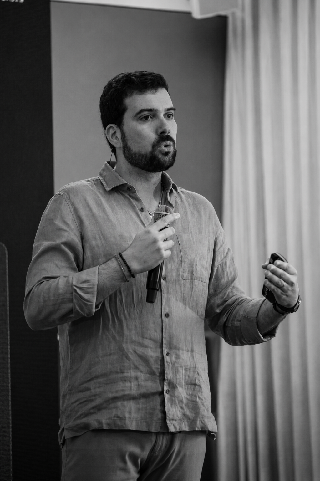 João speaking into a microphone during a presentation.
